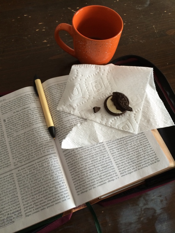 Picture of an open Bible with an Oreo cookie and a mug